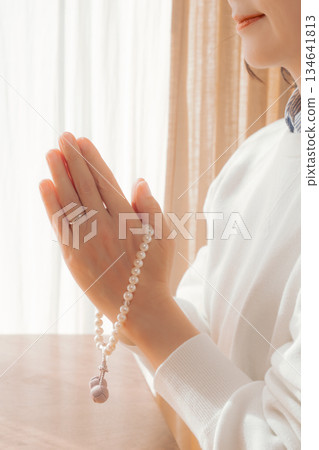 一位中年婦女在家中為逝者祈禱。 134641813