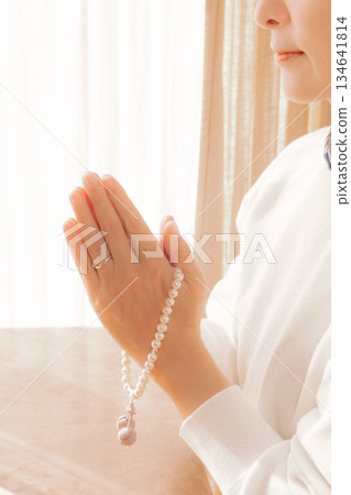 一位中年婦女在家中為逝者祈禱。 134641814