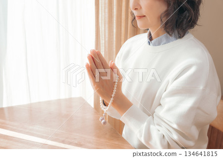 一位中年婦女在家中為逝者祈禱。 134641815