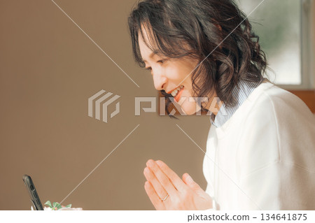 一位中年婦女在家中為逝者祈禱。 134641875