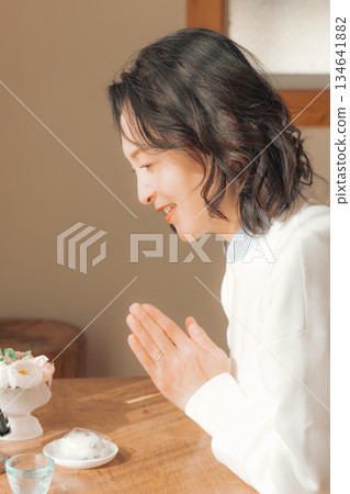 一位中年婦女在家中為逝者祈禱。 134641882