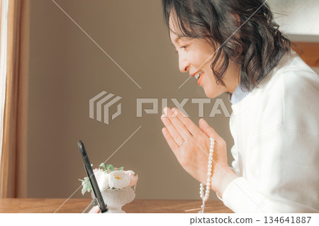 一位中年婦女在家中為逝者祈禱。 134641887
