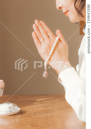 一位中年婦女在家中為逝者祈禱。 134641896