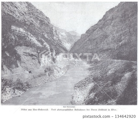 Rugged Mountain Gorge With River And Road Path In A Deep Valley Rugged Mountain Gorge With River And Road Path In A Deep Valley 134642920