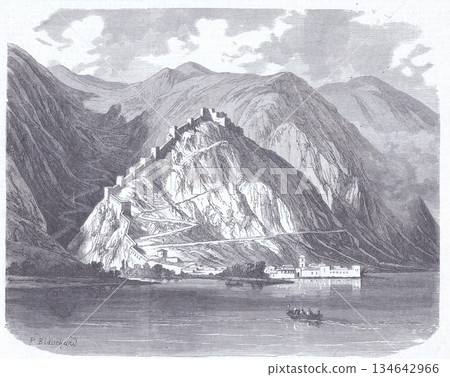 Ancient Mountain Fortress Along a Serene Lake With Village and Rugged Peaks in the Background 134642966