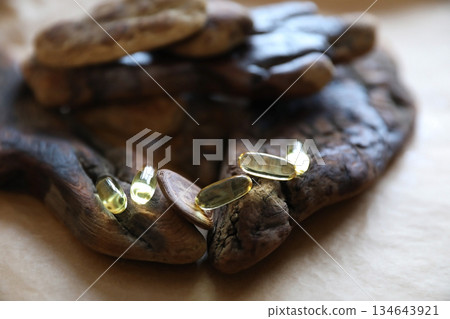 Omega 3 supplement capsules on a rustic wooden surface for health and wellness marketing. Natural health remedies and alternative medicine. 134643921