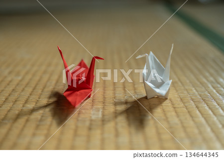 Two folded paper cranes on a tatami mat 134644345