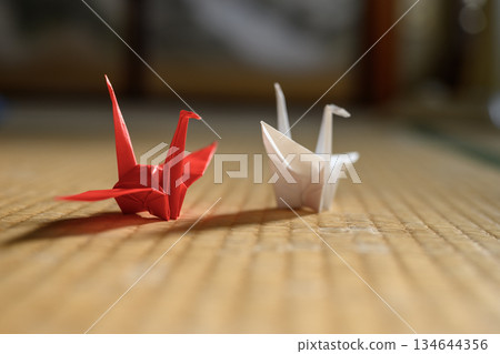榻榻米上放著兩隻折好的紙鶴。 榻榻米上放著兩隻折好的紙鶴。 134644356
