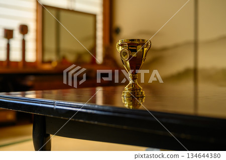 日式房間裡,一張桌子上擺放著一座金色的獎盃。 日式房間裡,一張桌子上擺放著一座金色的獎盃。 134644380