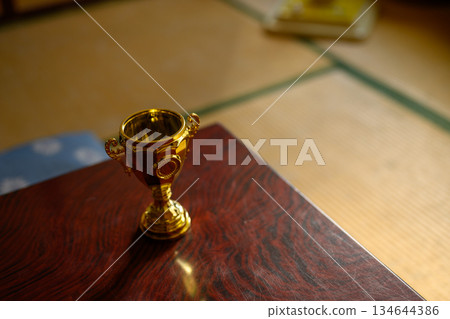 日式房間裡,桌上擺放著一座金色的獎盃。 日式房間裡,桌上擺放著一座金色的獎盃。 134644386