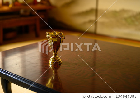 日式房間裡,桌上擺放著一座金色的獎盃。 日式房間裡,桌上擺放著一座金色的獎盃。 134644393