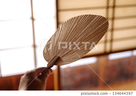 Hands holding a fan in a Japanese-style room 134644397