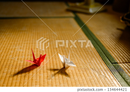 榻榻米上放著兩隻折好的紙鶴。 榻榻米上放著兩隻折好的紙鶴。 134644421