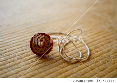 榻榻米墊上放著陀螺和繩子。 134644447