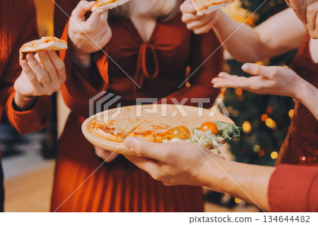 Festive Office Christmas Party with Delicious Food. A beautifully decorated office space with Christmas trees and festive lights, set up for a holiday party. 134644482