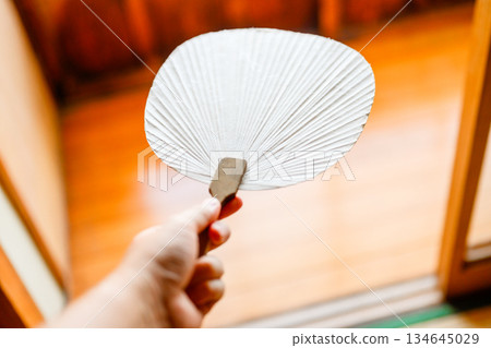 A white fan held in a Japanese-style room 134645029