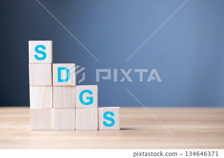 Wooden blocks display the letters SDGS, symbol Sustainable Development Goals, global progress, environmental responsibility, and commitment to long-term social and economic sustainability. 134646371