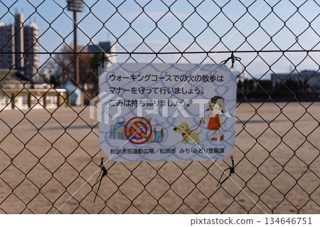 松原市民運動公園的遛狗禮儀標誌:高對比拍攝的鐵絲網陰影在逆光下與文字和插圖重疊。 松原市民運動公園的遛狗禮儀標誌:高對比拍攝的鐵絲網陰影在逆光下與文字和插圖重疊。 134646751