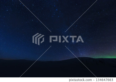 Starry night sky with Aurora over dark mountain Starry night sky with Aurora over dark mountain 134647663