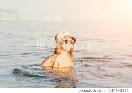 Woman Sunglasses Sea - A young woman wearing sunglasses and a hat floats in the sea. Woman Sunglasses Sea - A young woman wearing sunglasses and a hat floats in the sea. 134648231