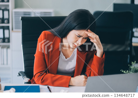 tired business woman sleepy and bored from sitting at a desk for a long time and has office syndrome 134648717