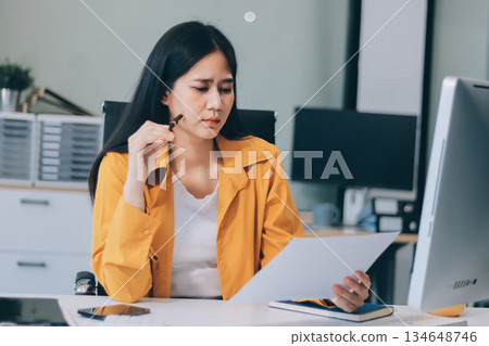Business woman using calculator for do math finance on wooden desk in office and business working background, tax, accounting, statistics and analytic research concept. Business woman using calculator for do math finance on wooden desk in office and business working background, tax, accounting, statistics and analytic research concept. 134648746