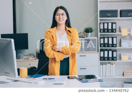 Business woman using calculator for do math finance on wooden desk in office and business working background, tax, accounting, statistics and analytic research concept. 134648762