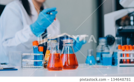 Portrait, science and happy woman on laptop in lab to research chemistry, test or innovation. Microscope, scientist and face of medical doctor in goggles for microbiology, healthcare or pharma study 134648781
