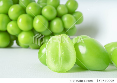 Fresh green grapes on white background with halved fruit detail Fresh green grapes on white background with halved fruit detail 134649096