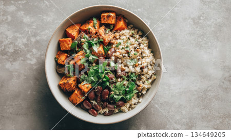 African-inspired vegan cereal porridge with baked sweet potato, red beans, and fresh herbs for a healthy plant-based lunch 134649205
