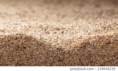 A dense layer of natural, unprocessed grain, creating the organic texture of the product, serves as the basis for agricultural and nutritional concepts 134649239