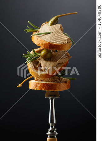 Sandwiches with liver pate garnished with rosemary and capers. Sandwiches with liver pate garnished with rosemary and capers. 134649286