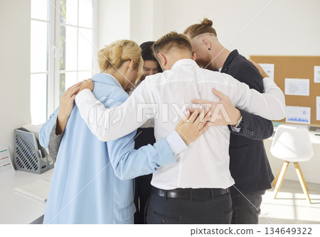 Colleagues standing in circle, embracing each other in office and fostering unity and support. Colleagues standing in circle, embracing each other in office and fostering unity and support. 134649322