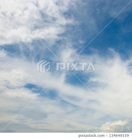 Scenic cloudscape featuring dense white clouds at horizon and wispy patterns above in natural daylight setting 134649339