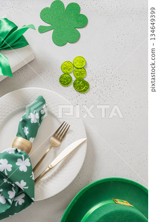 St Patricks day flat lay with green shamrock symbol and lucky coins on light background. Vertical format. Irish holiday decoration concept. St Patricks day flat lay with green shamrock symbol and lucky coins on light background. Vertical format. Irish holiday decoration concept. 134649399
