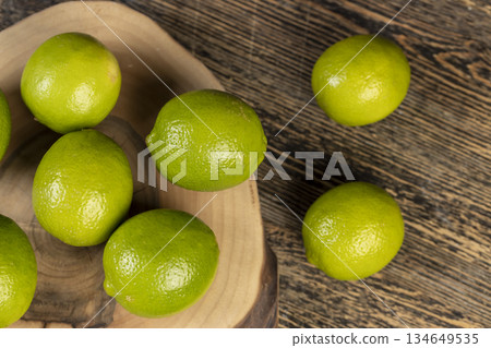 green ripe citrus limes scattered on a table in the kitchen, ripe and juicy lime fruits for cooking both sauces and drinks and other food green ripe citrus limes scattered on a table in the kitchen, ripe and juicy lime fruits for cooking both sauces and drinks and other food 134649535