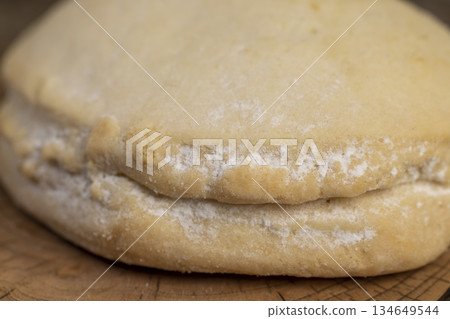 a whole fresh shortbread bun with cottage cheese filling on a board on the table, soft pastries stuffed with cottage cheese and sugar are on the board 134649544