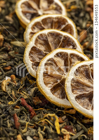 bright large dry lemon slices and green tea with pieces of fruit, high-quality tea with added flavors and pieces of fruit 134649553