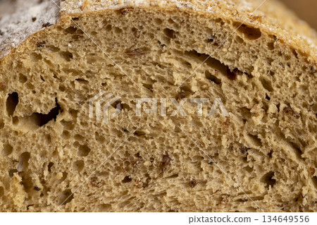 fresh soft loaf of bread on black slate, freshly baked soft loaf of rye bread cut in half 134649556