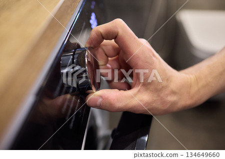 Individual Interacting with a Modern Washing Machines Control Panel for Efficient Laundry Tasks Individual Interacting with a Modern Washing Machines Control Panel for Efficient Laundry Tasks 134649660