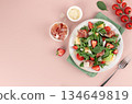 Fresh arugula salad with prosciutto, strawberries, cherry tomatoes, melon, parmesan. Healthy summer lunch concept. 134649819