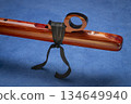 detail of native American style flute with fetish handcrafted from aromatic cedar wood against art paper 134649940