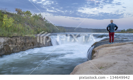 lonely man contemplating the Norden Chute on Niobrara River in Nebraska, late summer sunrise scenery lonely man contemplating the Norden Chute on Niobrara River in Nebraska, late summer sunrise scenery 134649942