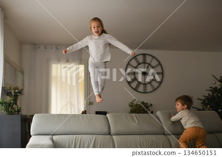 The children are jumping with joy on the sofa at Christmas 134650151