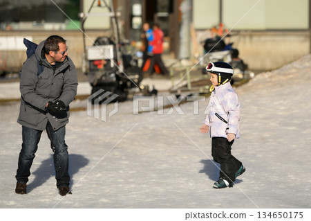 A girl on skis stands on a carpet ski lift in a glass tunel A girl on skis stands on a carpet ski lift in a glass tunel 134650175