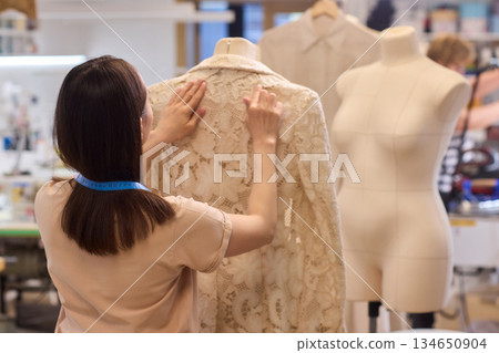 Fashion Design Tailoring a Beautiful Lace Garment on a Dress Form for Perfect Fit Fashion Design Tailoring a Beautiful Lace Garment on a Dress Form for Perfect Fit 134650904