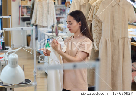 A Talented Fashion Designer is Diligently Engaged at Work in a Creative and Inspiring Studio Space A Talented Fashion Designer is Diligently Engaged at Work in a Creative and Inspiring Studio Space 134650927