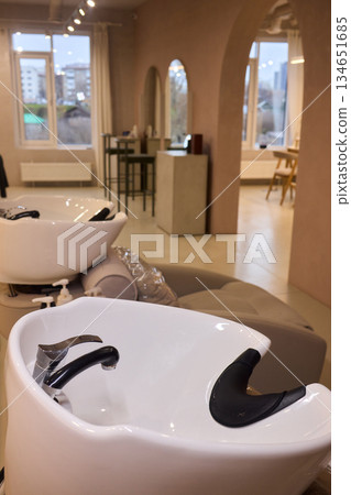 Salon wash station, Elegant hair wash station setup, Modern glossy porcelain hair washing basin setup, Sterile bright salon with professional hair washing and treatment area Salon wash station, Elegant hair wash station setup, Modern glossy porcelain hair washing basin setup, Sterile bright salon with professional hair washing and treatment area 134651685