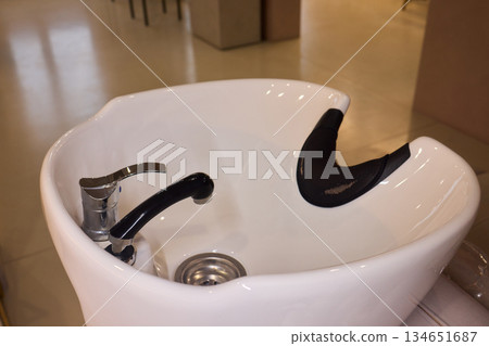 Salon wash station, Elegant hair wash station setup, Modern glossy porcelain hair washing basin setup, Sterile bright salon with professional hair washing and treatment area 134651687