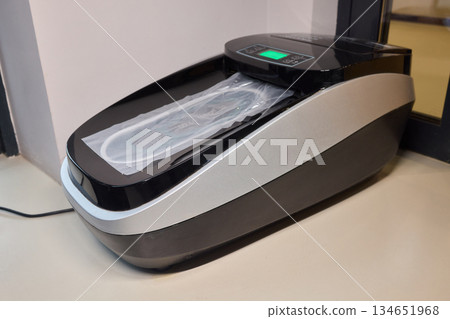 Sleek countertop device for clean foot coverings at health facilities, Efficient shoe cover dispensing unit designed for hygienic entrances in medical environments 134651968